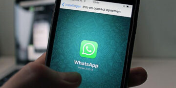 Foto de uma mão segurando um smartphone com a tela do aplicativo WhatsApp aberta, representando um tutorial de como colocar o link do WhatsApp no Instagram.