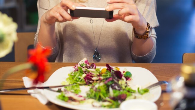 mulher tirando foto comida para post instagram