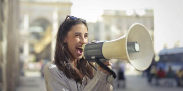 Foto de uma mulher usando um megafone, representando uma estratégia de divulgação no Instagram.