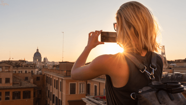 Mulher tirando fotos da cidade para postar no Instagram sem perder a qualidade