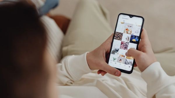 Mulher com celular aberto no aplicativo do Instagram acessando a aba explorar