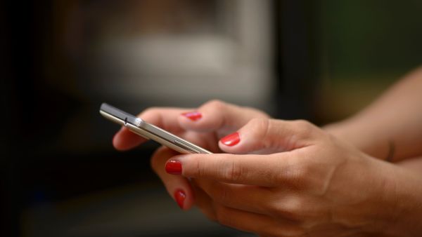 Mulher com celular procurando formas de impedir o encerramento repentino do Instagram