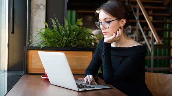 Mulher trabalhando em tarefas de social media no laptop