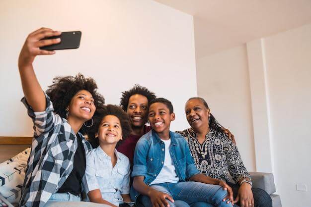 Familia sorrindo tirando foto selfie no sofa