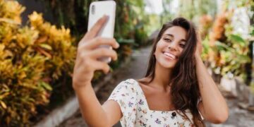 Mulher feliz sorrindo tirando foto selfie no jardim