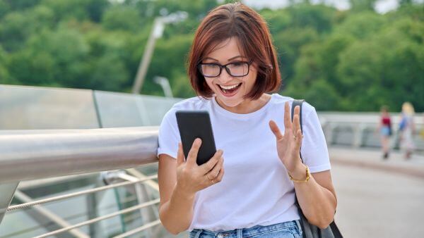 Mulher sorrindo olhando para o celular