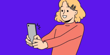 mulher segurando telefone e tirando uma selfie para postar antes d programar stories instagram