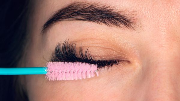 Lash designer aplicando extensão de cílios em cliente