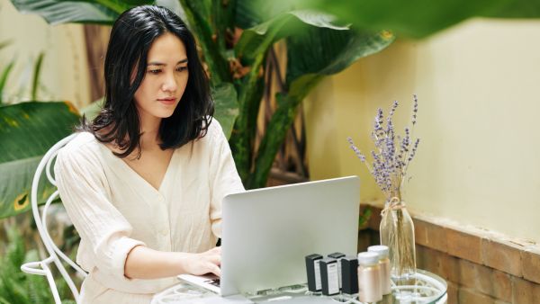 Microempreendedora escrevendo frases para loja de perfume Instagram no seu notebook